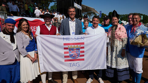 Am Ende des Festzuges haben der Pfungstädter Bürgermeister Patrick Koch und das Hessentagspaar, Natalie Reining und Simon Schmitz, vor der Ehrentribüne die Hessentagsfahne an den Fritzlarer Bürgermeister Hartmut Spogat und das Hessentagspaar 2024, Franziska und Kevin Wathling, überreicht.