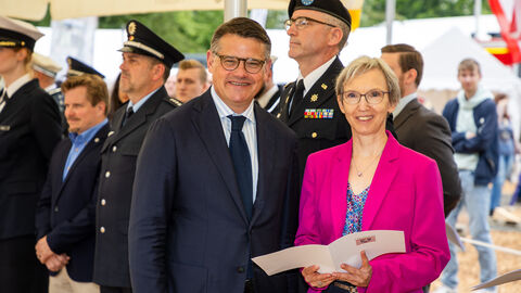 Ministerpräsident Boris Rhein überreicht einer Dame eine Urkunde.