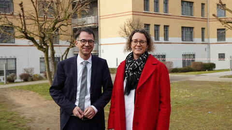 Justizminister Christian Heinz und Nora Stang-Albrecht Ein Mann und eine Frau stehen nebeneinander vor einem Gefängnisgebäude