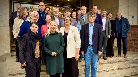 Mehrere Menschen stehen zusammen auf einer Treppe.